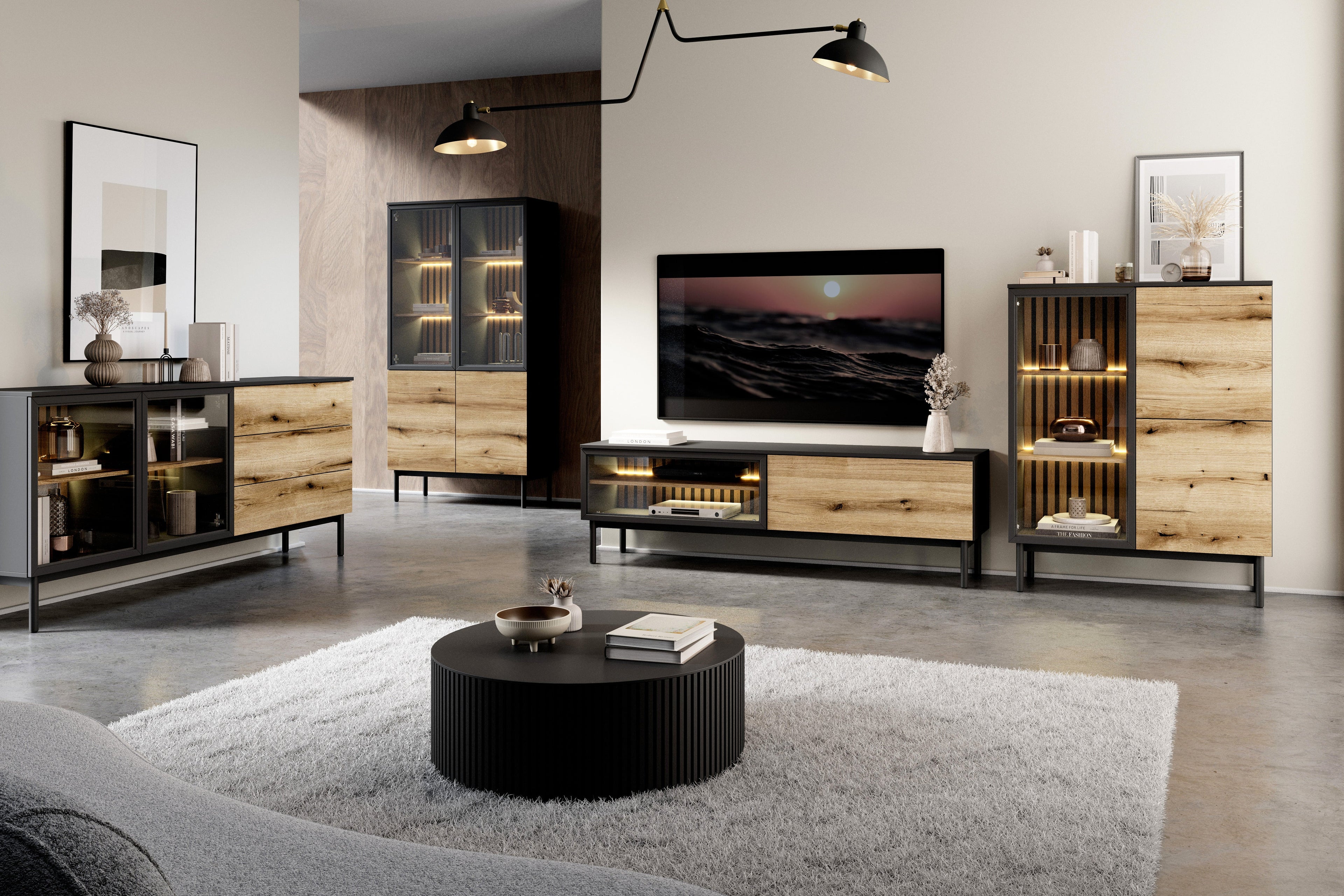 Modern living room with a sleek entertainment center featuring a TV unit, storage cabinets, and a round coffee table. The furniture combines black metal frames with warm wood finishes and integrated LED lighting for a stylish, contemporary look.